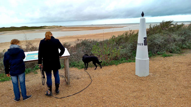 De laatste grenspaal met op de achtergrond de monding van het Zwin en de Noordzee