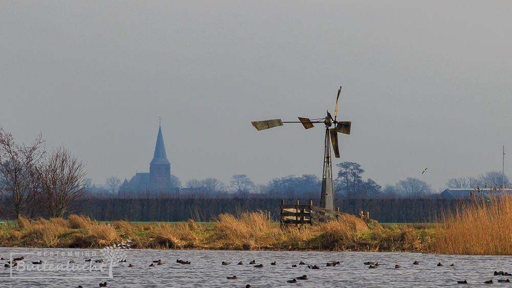 Molen in Willeskop met de kerk van Benschop op achtergrond